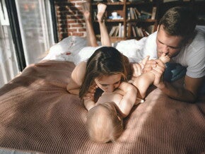 foreldre og baby på sengen foreldre og baby på sengen